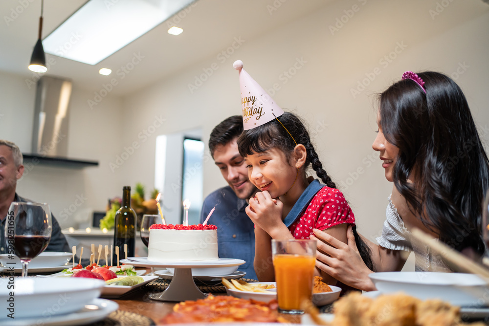 Multi-ethnic big family having a birthday party for young kid daughter. 