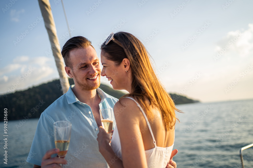 Caucasian young couple drinking champagne while having party in yacht. 