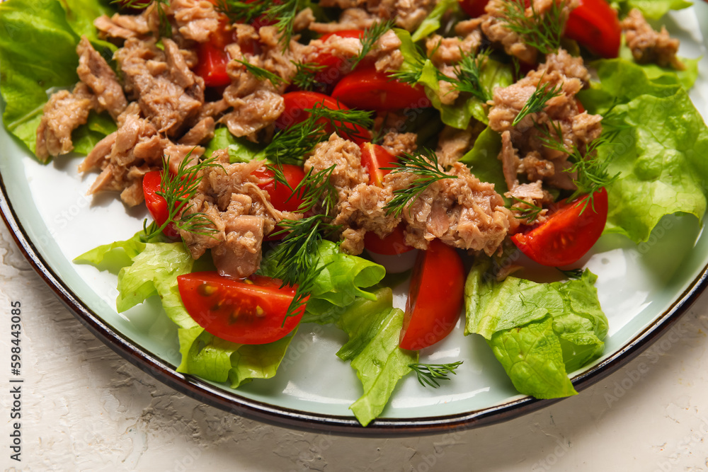 Plate with delicious tuna salad on white table