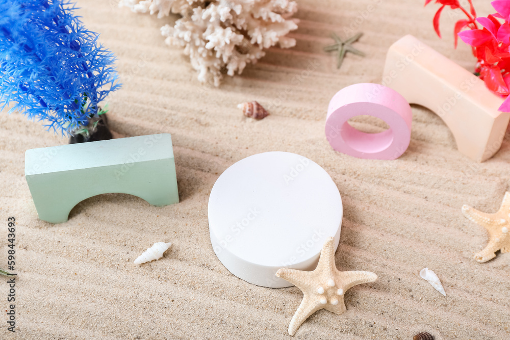 Decorative plaster podiums, coral, seaweed and starfish in sand