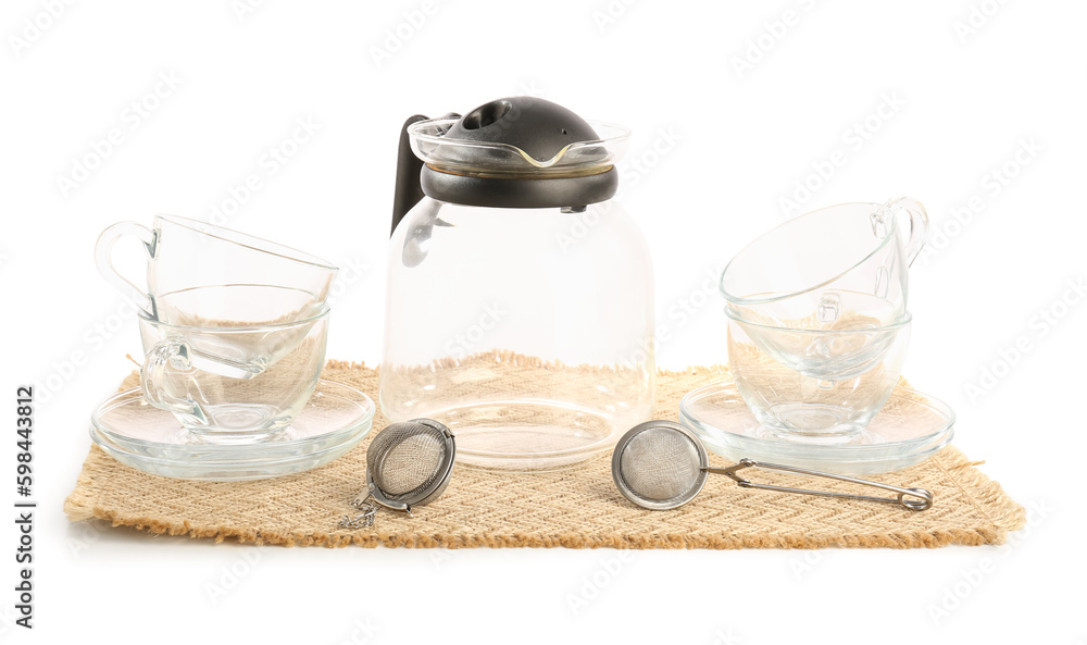 Wicker mat with teapot, glass and infusers isolated on white background