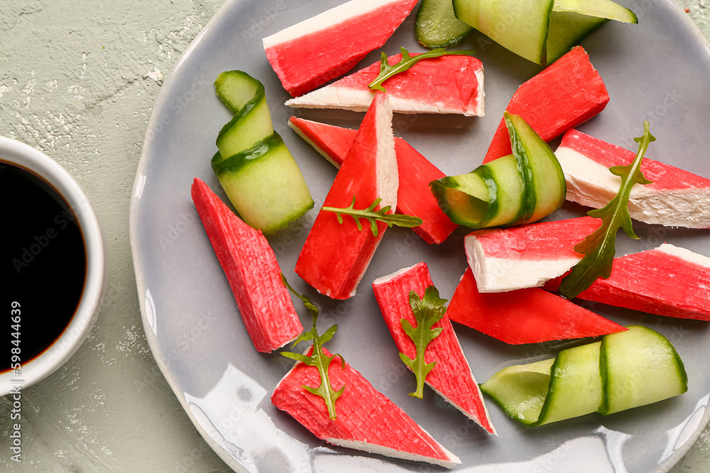 Plate with tasty crab sticks on light background, closeup