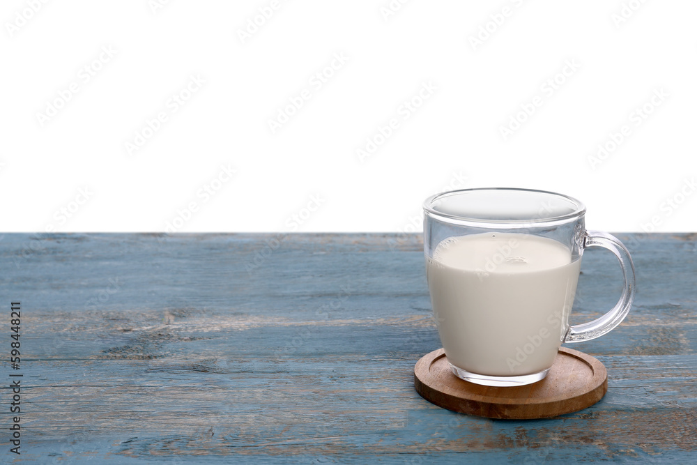 Cup of milk on blue wooden table against white background