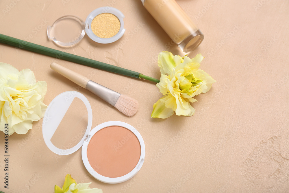 Beautiful daffodils with different cosmetics on beige background