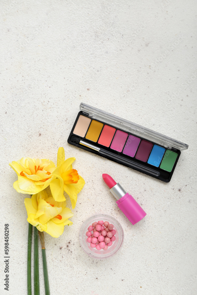 Beautiful daffodils with different cosmetics on white background