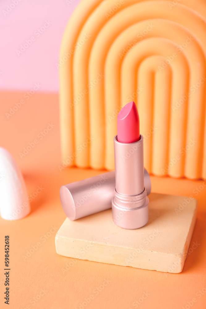 Decorative plaster podiums and lipstick on color background