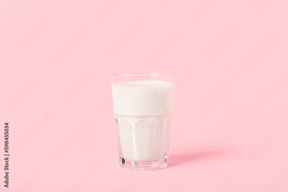 Glass of milk on pink background