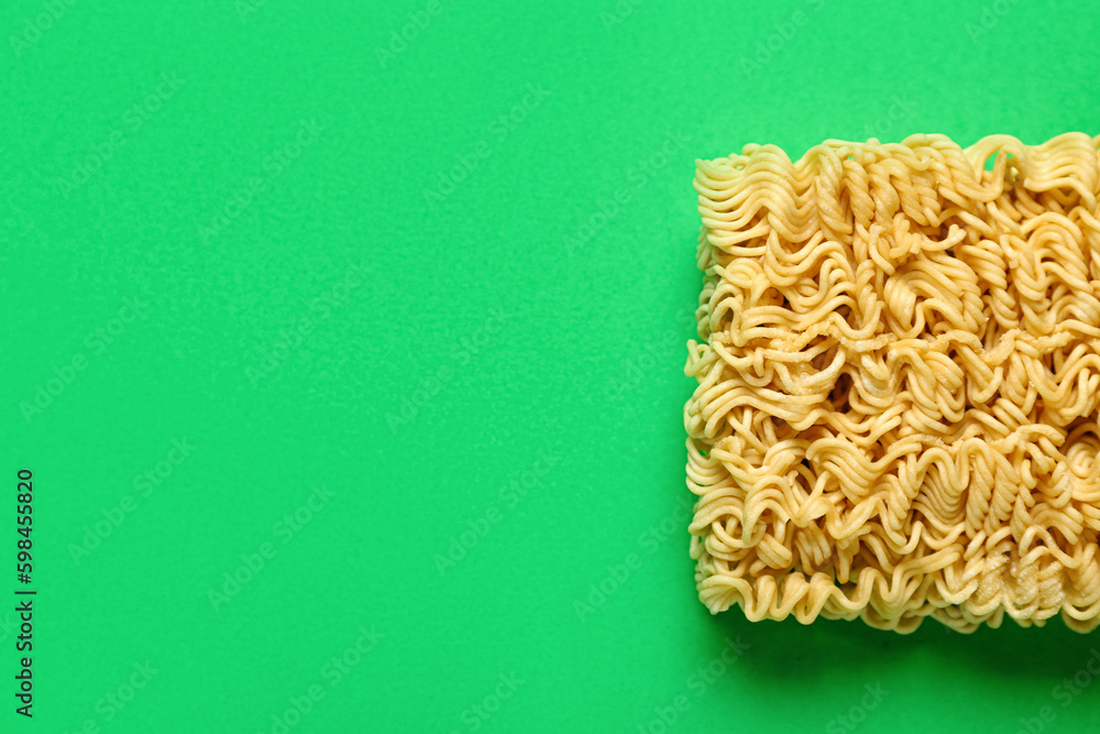 Raw instant noodles on green background