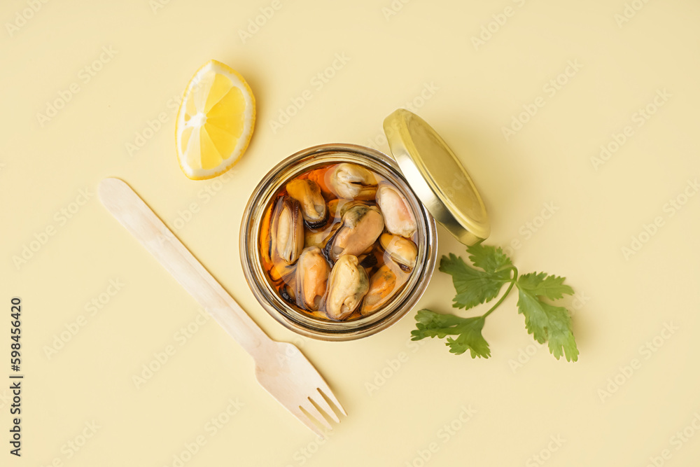 Jar with pickled mussels on beige background