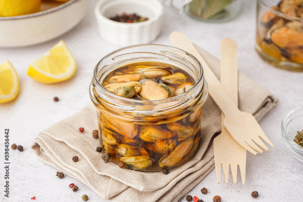 Jar with pickled mussels on white background