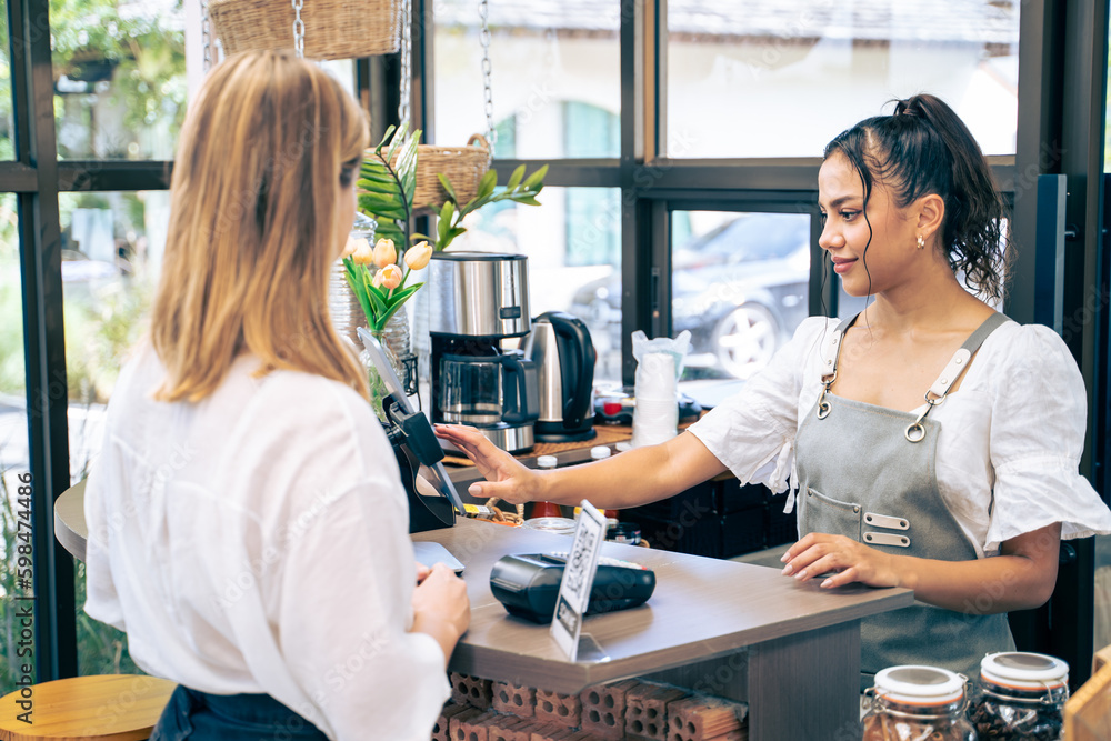 Caucasian attractive women receive coffee from waiter in coffee house. 