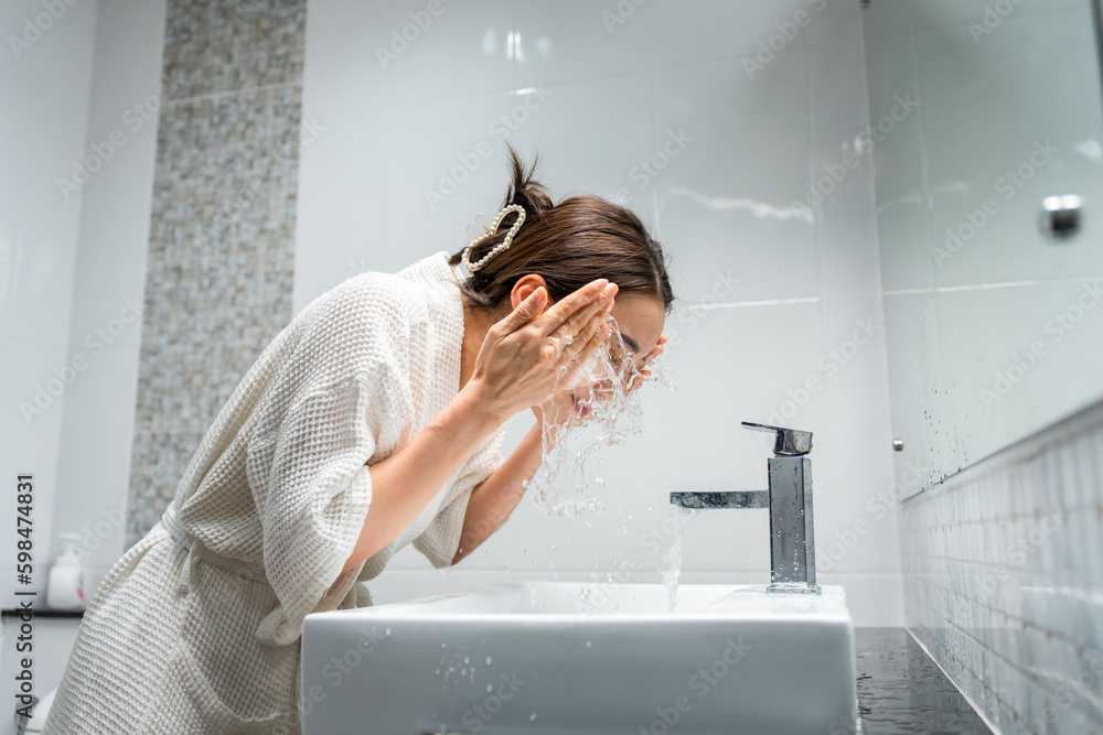 Asian beautiful woman washing her clean face with facial foam and water. 