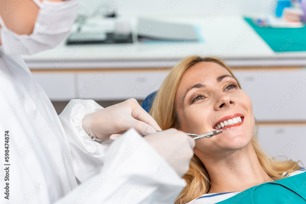 Female dentist examine tooth to Caucasian girl at dental health clinic. 