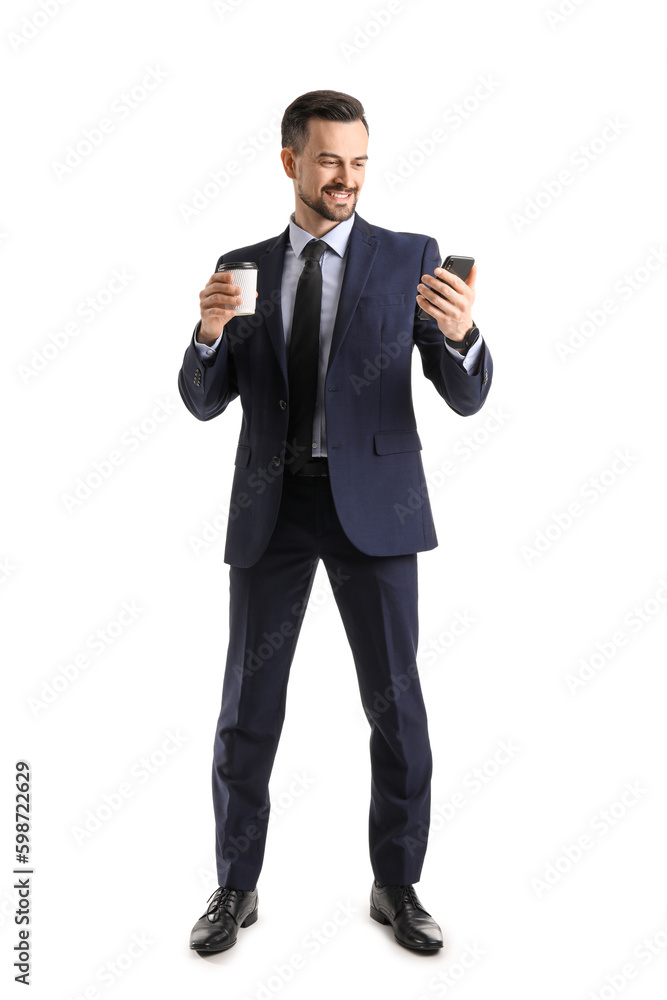 Handsome businessman with cup of coffee and mobile phone on white background