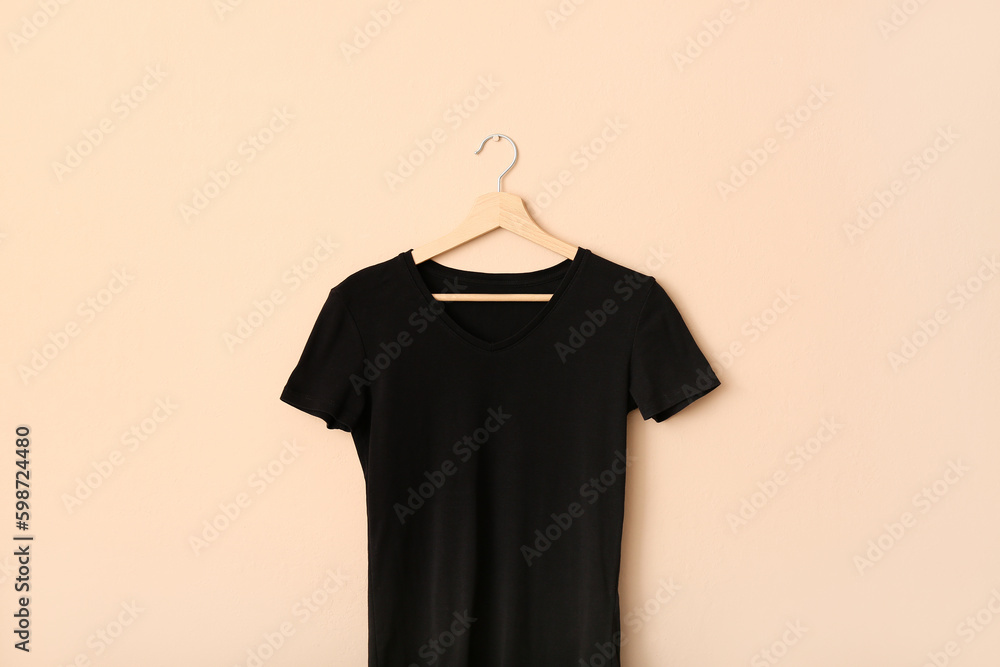 Black t-shirt hanging on light wall