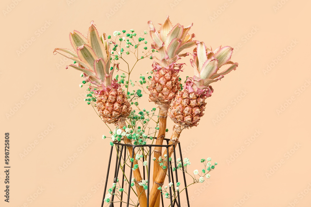 Vase with decorative pineapples on beige background, closeup