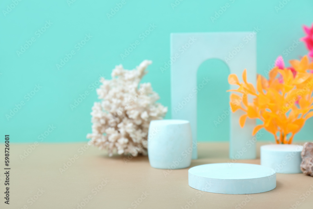 Decorative plaster podiums, seaweed and coral on turquoise background