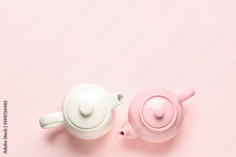 Different teapots on pink background