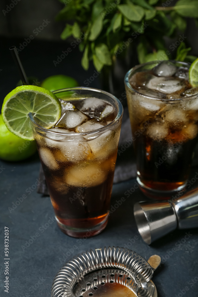 Glasses of cold Cuba Libre cocktail on dark background