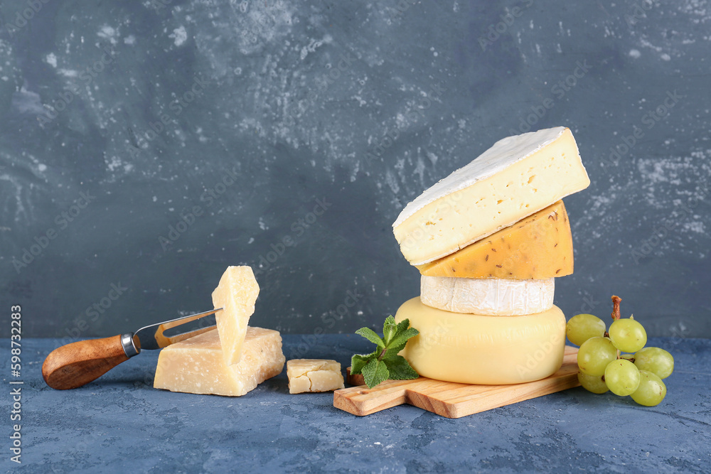 Wooden board with different types of cheese on table