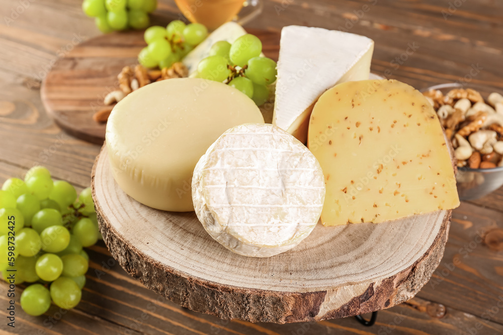 Board with different types of cheese on wooden background