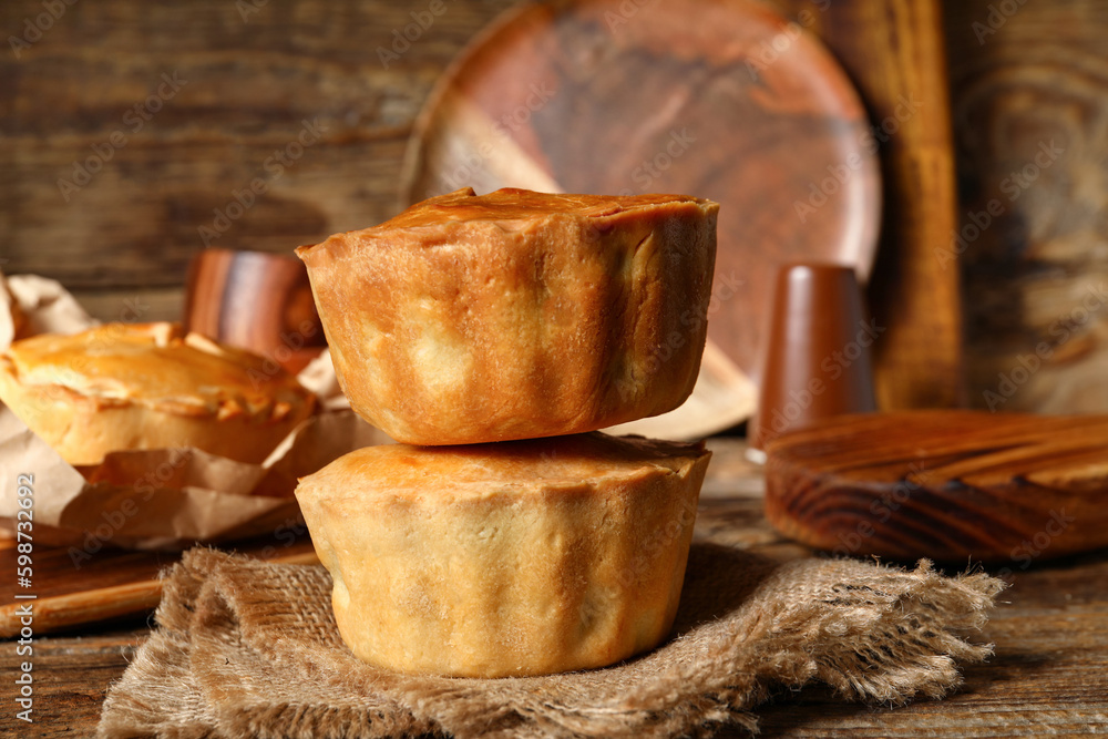 Tasty meat pot pies on wooden background