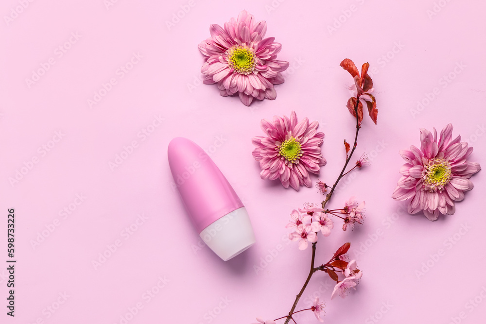 Deodorant with flowers and blooming branch on pink background