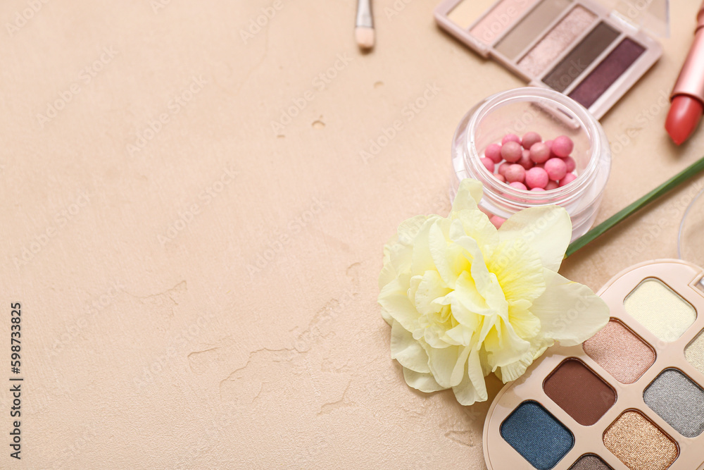 Beautiful daffodils with different cosmetics on beige background