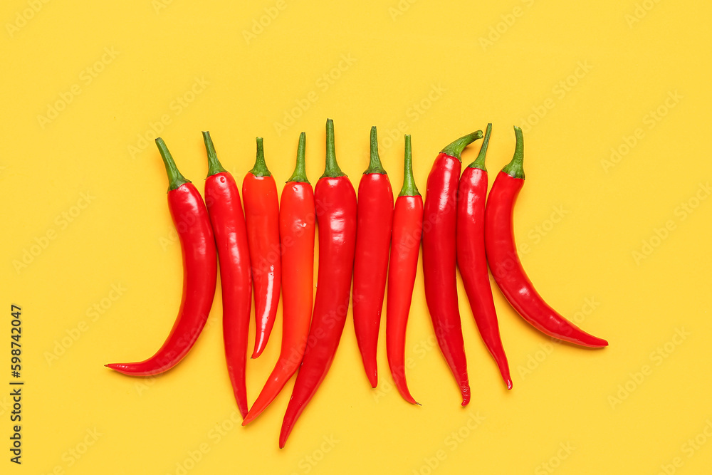 Fresh hot chili peppers on yellow background