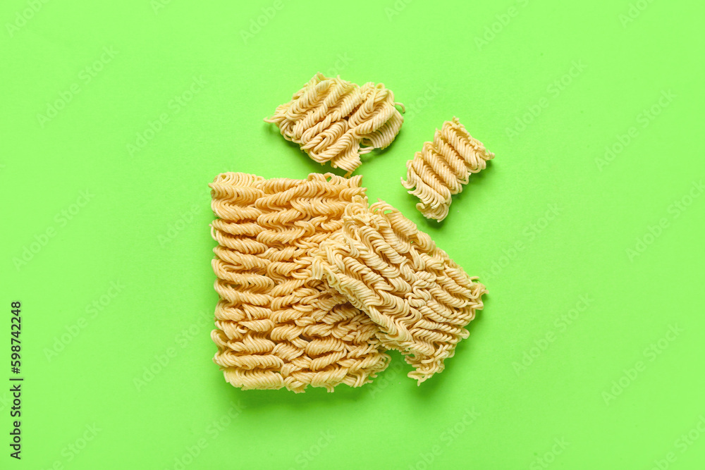 Raw instant noodles on light green background