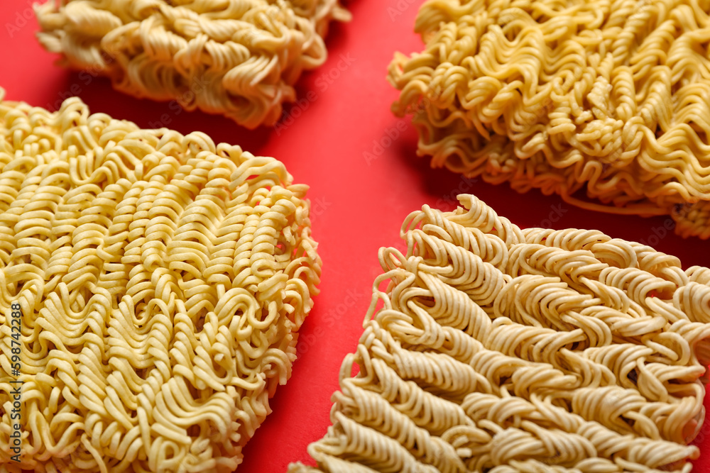 Raw instant noodles on red background