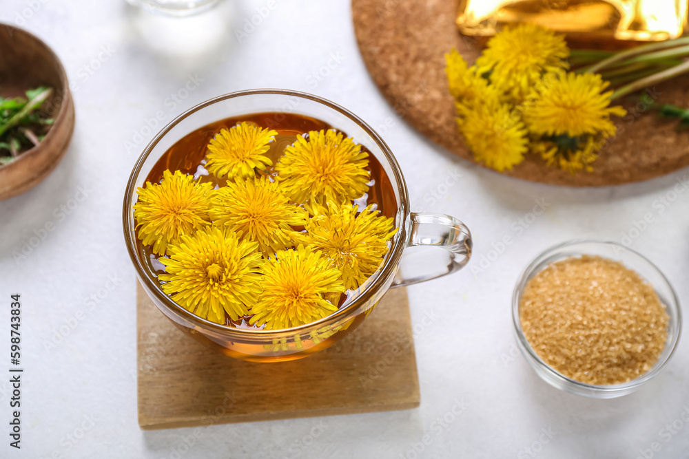 Glass cup of healthy dandelion tea on white background