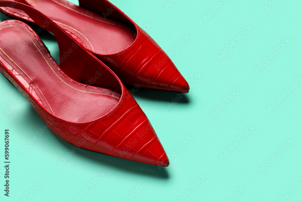 Pair of stylish red shoes on color background