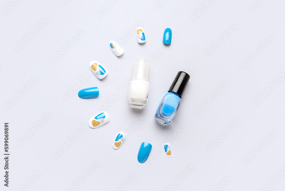 Press-on nails with polishes on white background