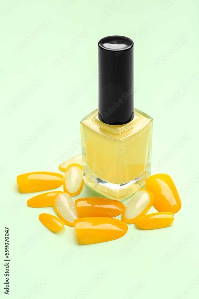 Press-on nails with polish on green background