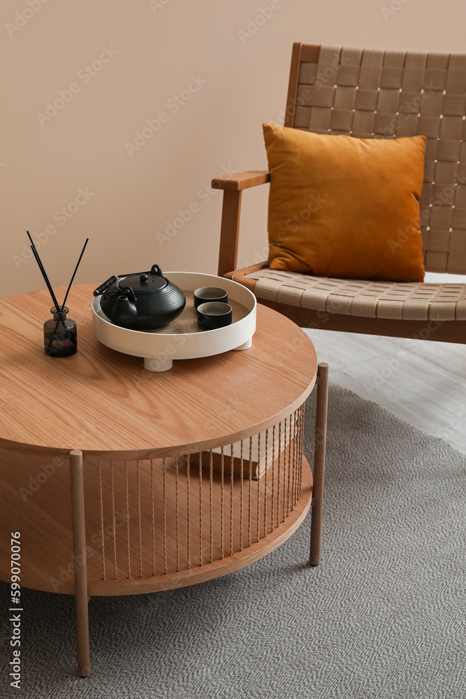 Coffee table with teapot, reed diffuser and book in living room