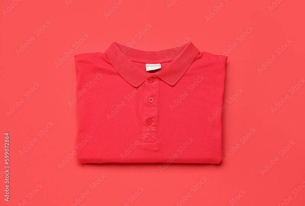 Folded red t-shirt on color background