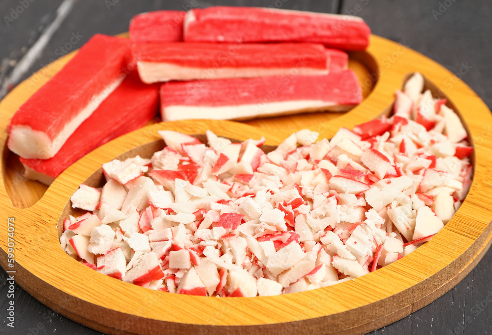 Plate with tasty chopped crab sticks on table, closeup