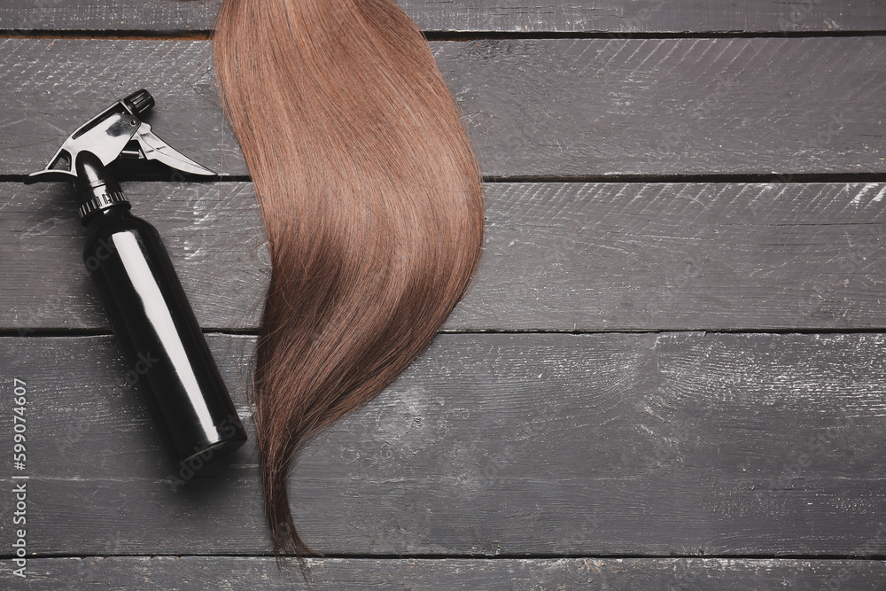 Brown hair with spray on dark wooden background