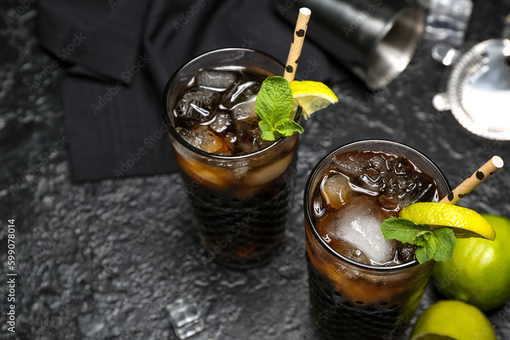 Glasses of cold Cuba Libre cocktail on dark background