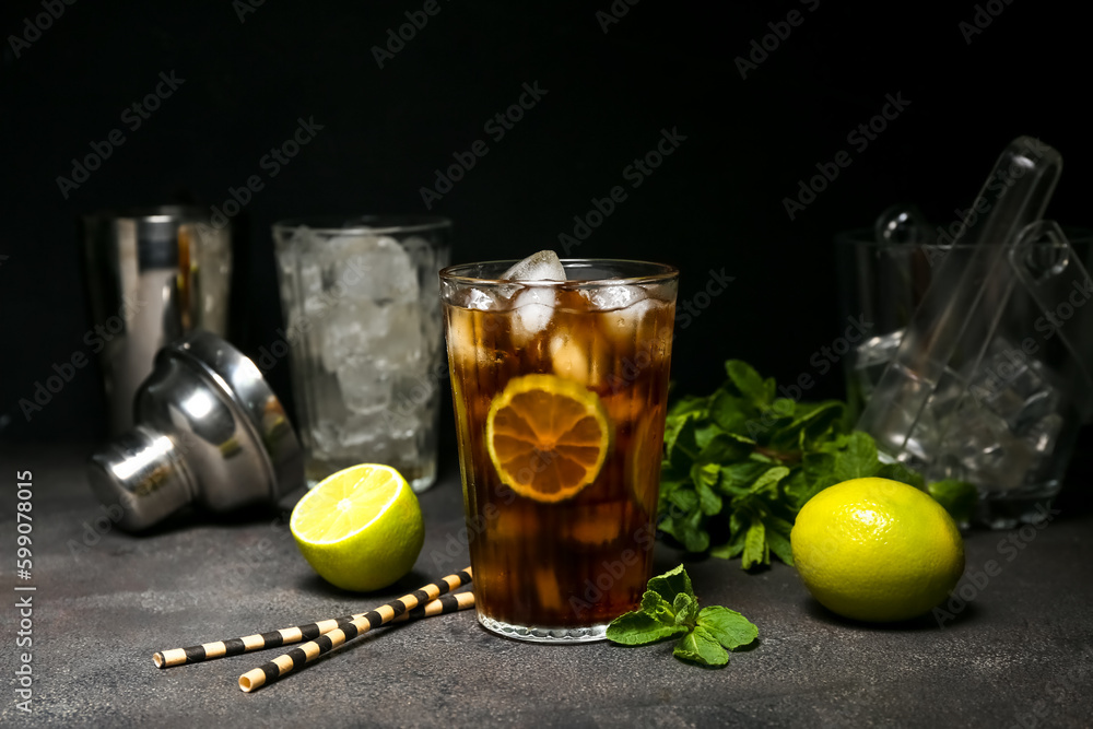 Glass of cold Cuba Libre cocktail on dark background