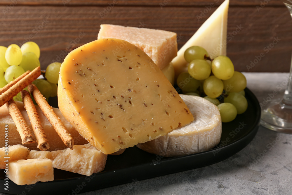 Tray with different types of cheese on table, closeup