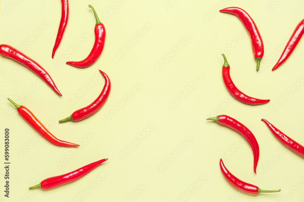 Fresh hot chili peppers on pale yellow background