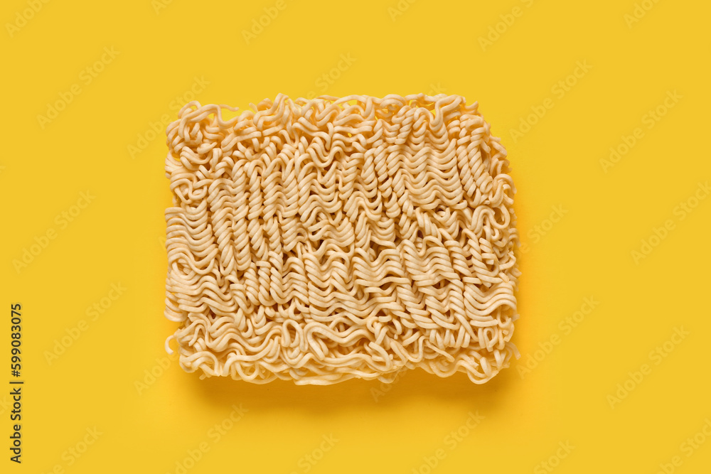 Raw instant noodles on yellow background