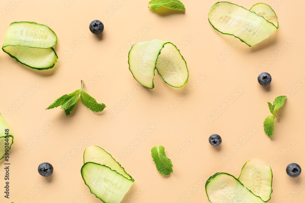 Slices of cucumber with blueberry and mint on beige background