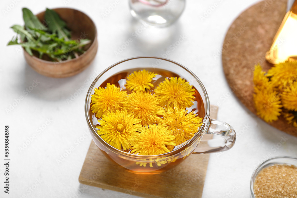 Glass cup of healthy dandelion tea on white background