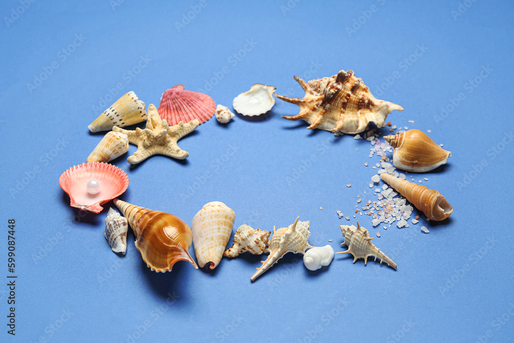 Frame made of sea shells, salt and starfish on blue background