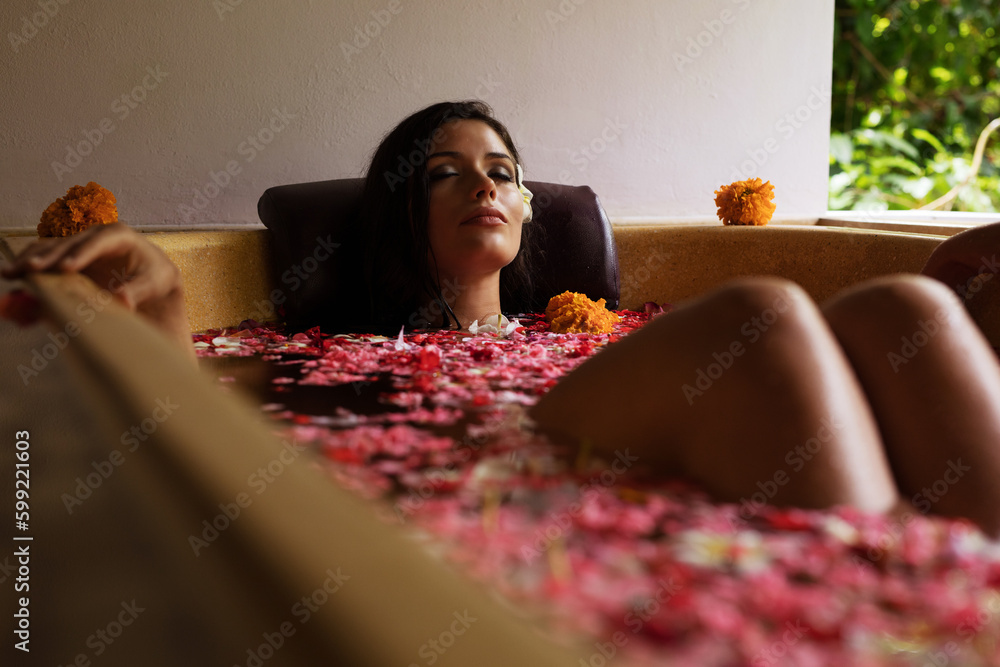 Attractive woman in bathtub with flowers