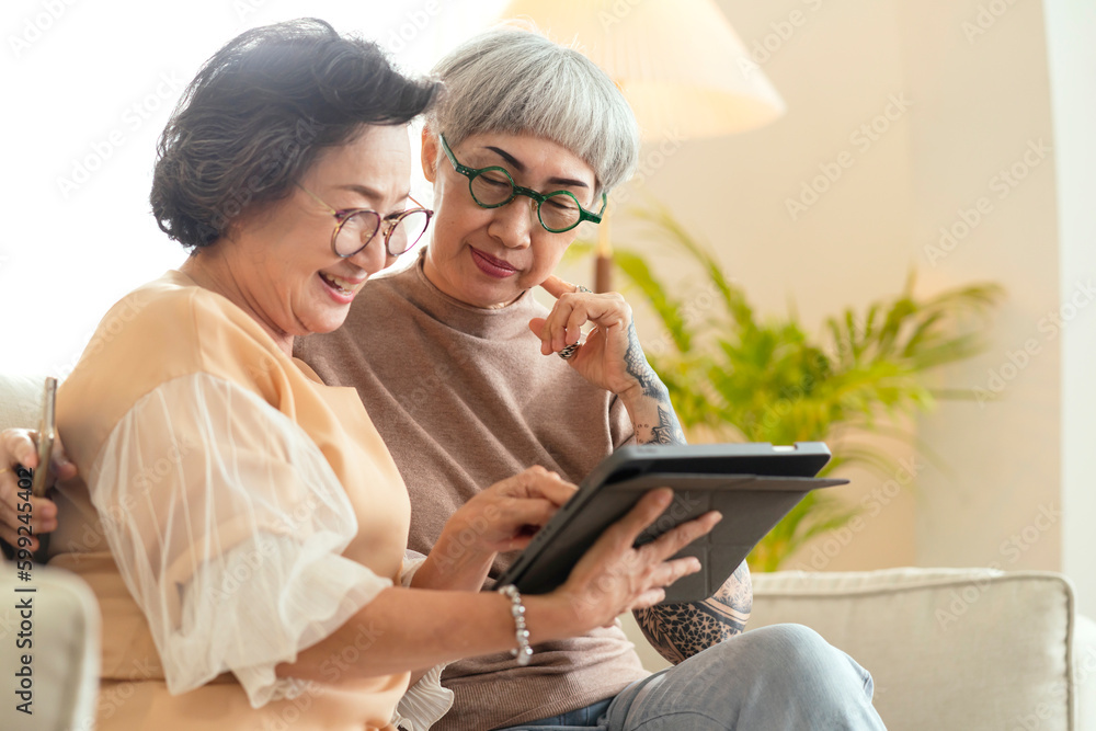 senior old asian aunt retired woman friend looking to old photo memory of herself together with good