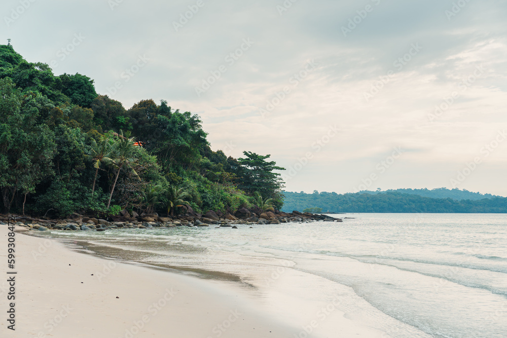 Tropical sea with the beach and the forest in gloomy day